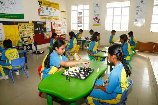 Students playing chess together in a classroom during an activity session