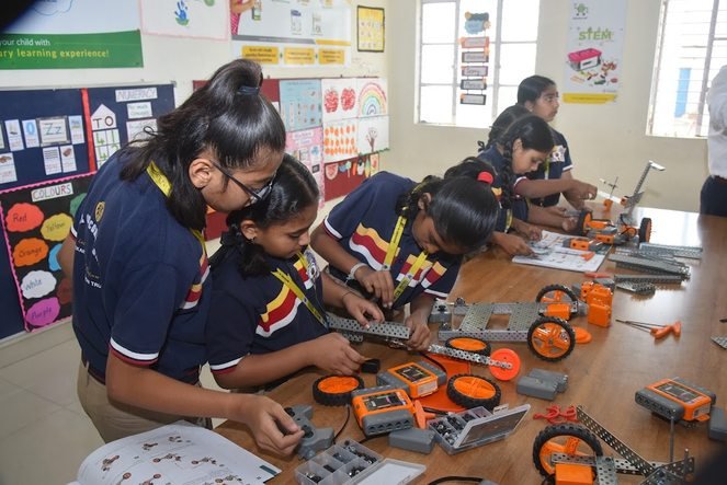 Students building robotics kits together at a workbench